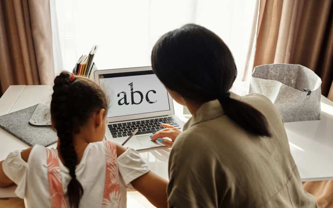 A girl is schooling at home with a laptop and a pencil taking notes. Her mother is helping her. Schools need online directories.